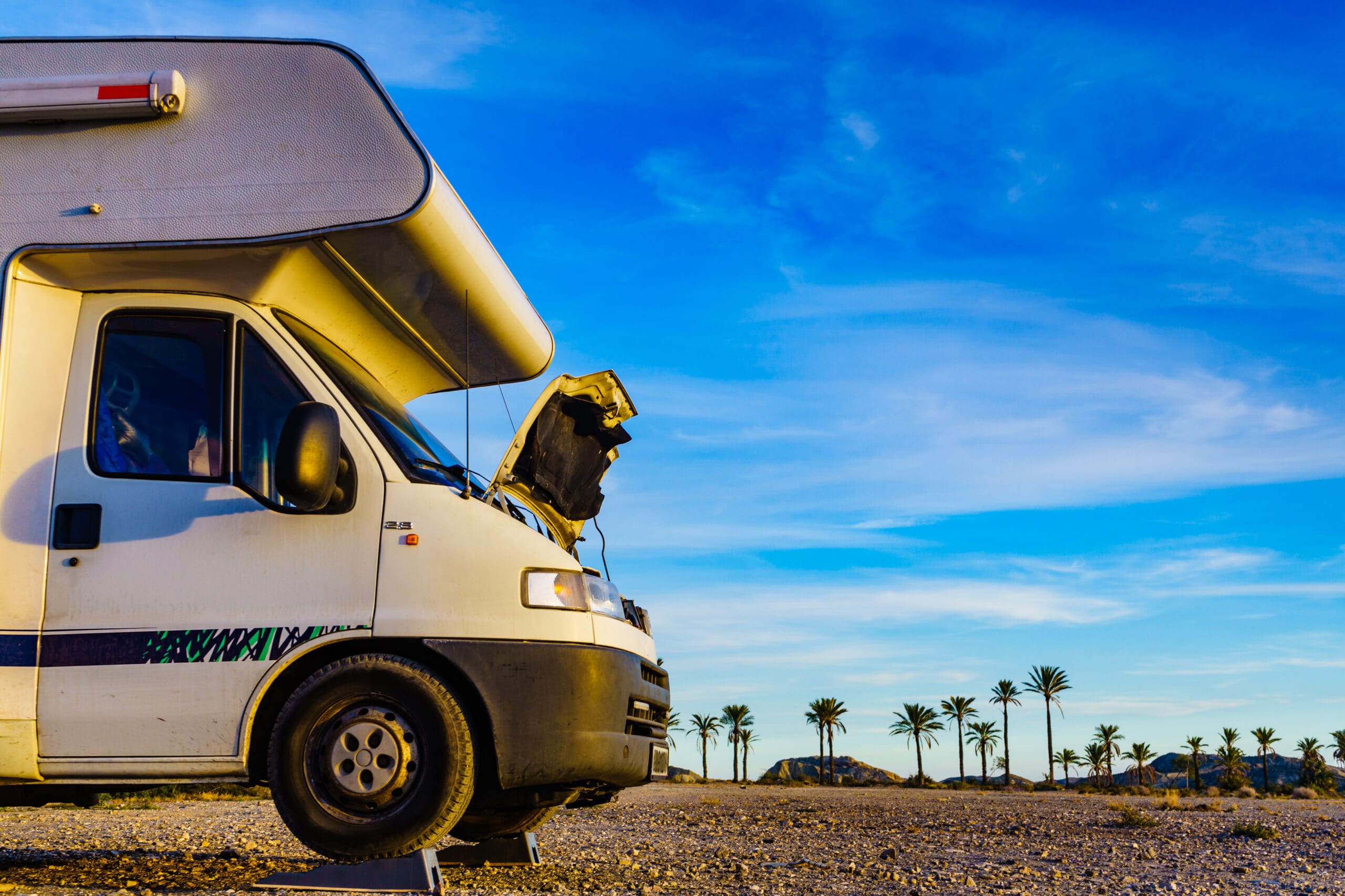 Camper van with open hood in desert